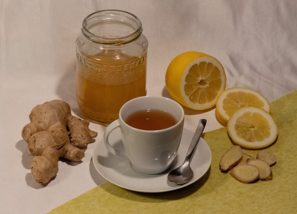 Tasse de boisson chaude accompagnée de gingembre frais, de citron et de miel.